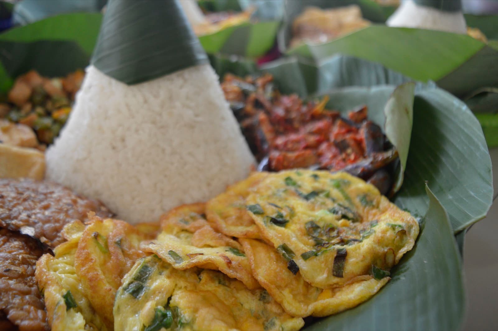 Nasi tumpeng tersaji di atas daun pisang untuk syukuran